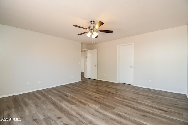 spare room featuring a ceiling fan, baseboards, and wood finished floors