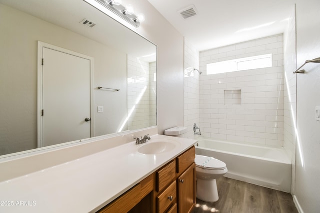 full bath with toilet, vanity, wood finished floors, and visible vents