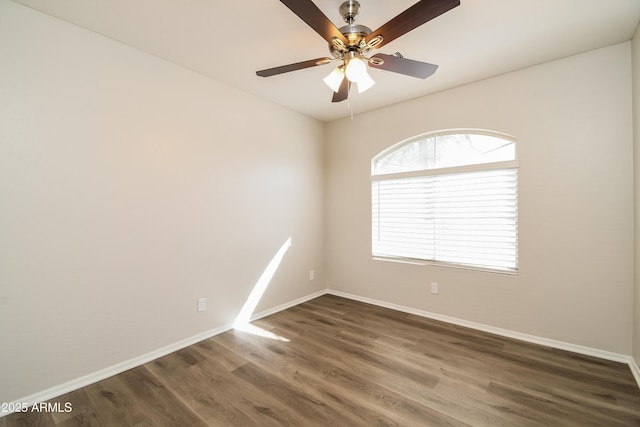 spare room featuring a ceiling fan, baseboards, and wood finished floors