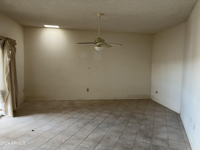 tiled spare room featuring ceiling fan and a textured ceiling