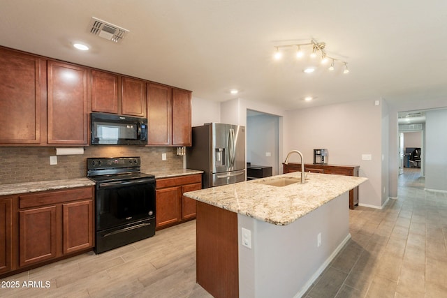 7238 N 126th Ln, Glendale, AZ 85307 - kitchen featuring black appliances, brown cabinets, decorative backsplash, light wood-style flooring, and light stone countertops