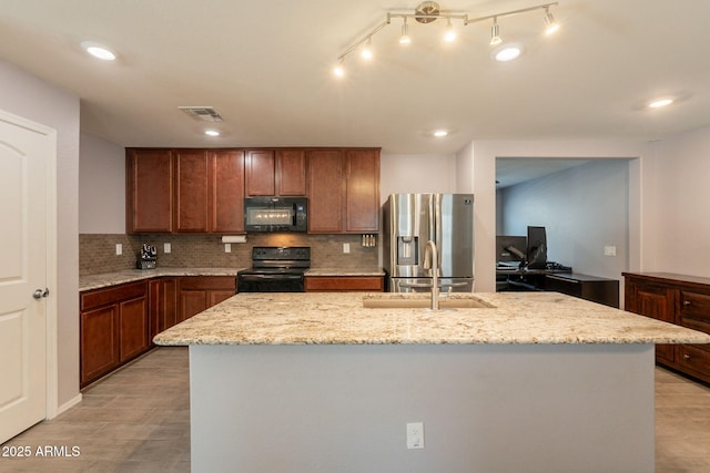 7238 N 126th Ln, Glendale, AZ 85307 - kitchen featuring black appliances, brown cabinetry, decorative backsplash, light stone countertops, and a center island with sink