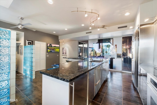 kitchen featuring a wealth of natural light, ceiling fan, a spacious island, and sink