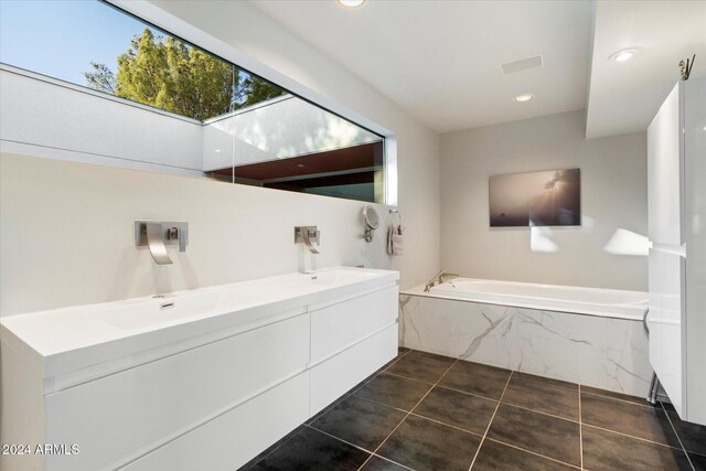 bathroom featuring tile patterned floors, tiled bath, and vanity