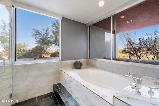 bathroom featuring tile patterned flooring and tiled tub