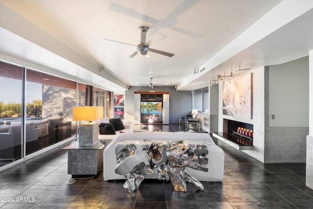 living room featuring ceiling fan and a large fireplace