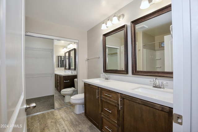 bathroom featuring a shower, wood-type flooring, vanity, and toilet