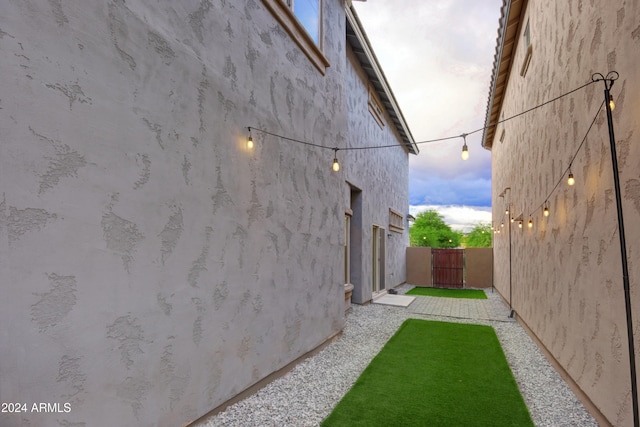 property exterior at dusk featuring a lawn