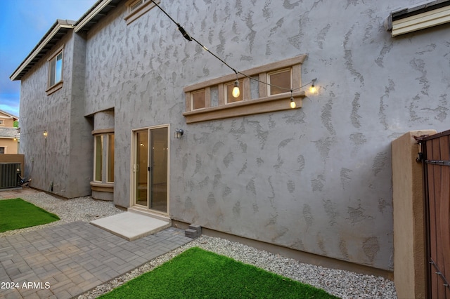 rear view of property with central air condition unit and a patio