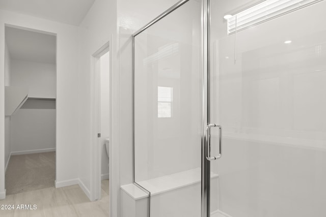 bathroom with a shower with door