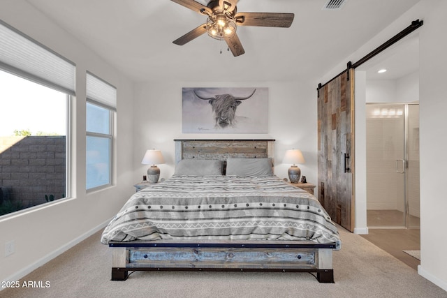 carpeted bedroom with a barn door and ceiling fan