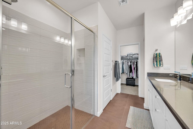 bathroom featuring tile patterned flooring, vanity, and walk in shower