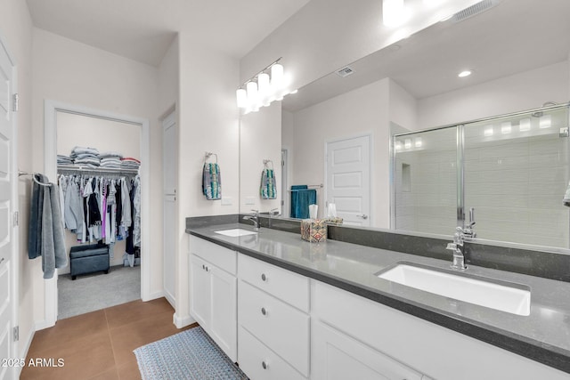 bathroom featuring tile patterned floors, vanity, and a shower with door