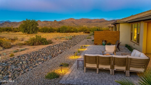 view of patio / terrace featuring a mountain view and an outdoor living space with a fire pit