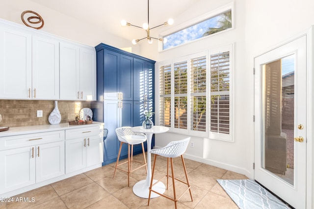 kitchen featuring decorative backsplash, white cabinets, blue cabinetry, and light tile patterned floors