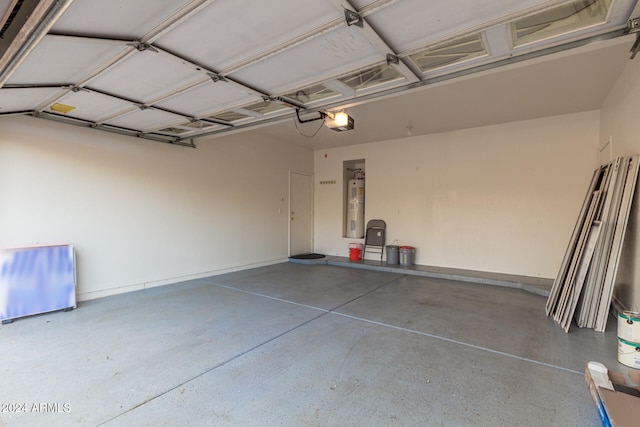 garage with a garage door opener and strapped water heater