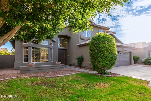 view of front of home with a front yard and a garage