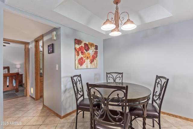 dining area featuring light tile patterned flooring, baseboards, and a chandelier