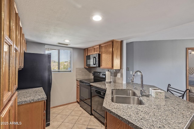 kitchen with black appliances, a sink, a peninsula, brown cabinetry, and tasteful backsplash