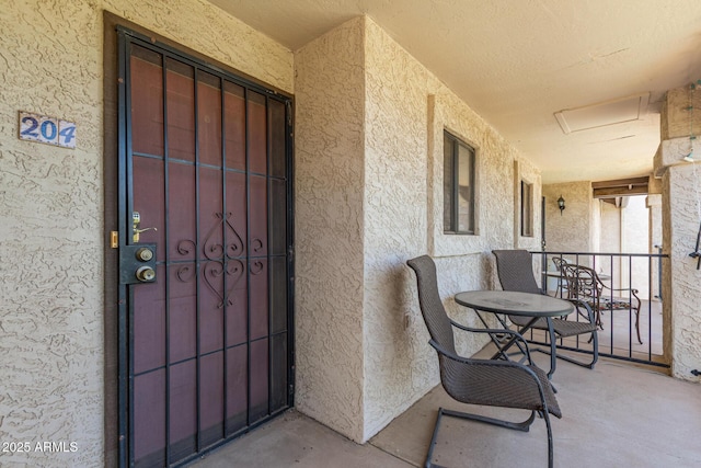 doorway to property with stucco siding and covered porch