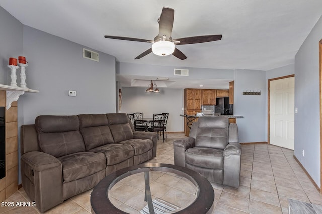 living area with ceiling fan, light tile patterned flooring, and baseboards
