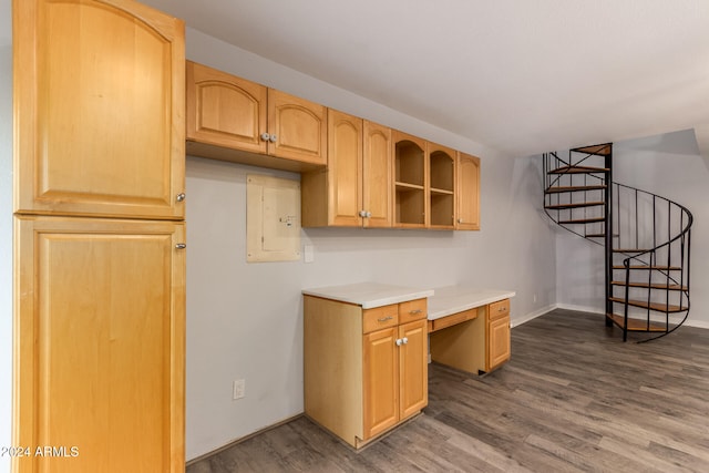 kitchen with built in desk, electric panel, hardwood / wood-style flooring, and light brown cabinets