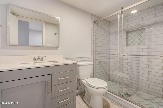 bathroom featuring an enclosed shower, vanity, and toilet