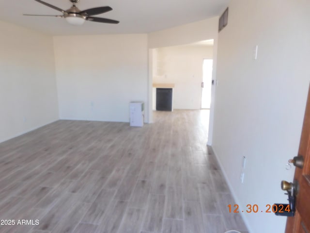 spare room with ceiling fan and light wood-type flooring