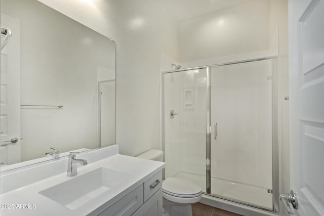 bathroom featuring toilet, a shower stall, and vanity