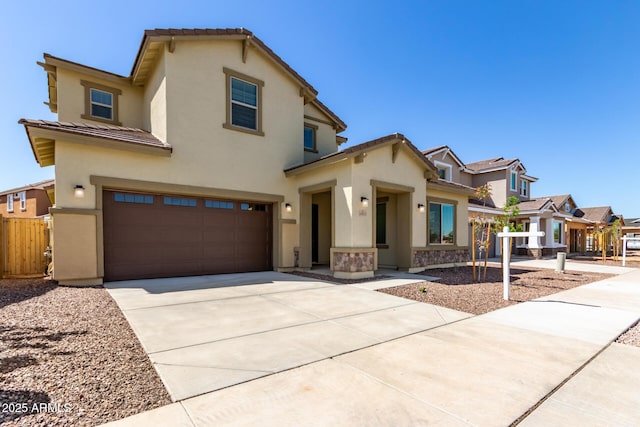 view of front of property with a garage, concrete driveway, fence, and stucco siding