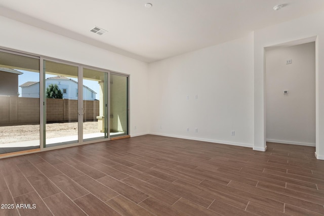 spare room with wood tiled floor, visible vents, and baseboards