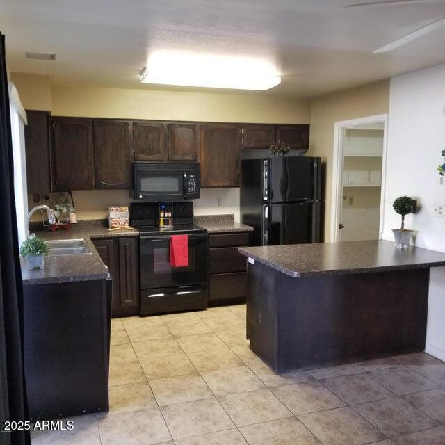 2645 W Elm St, Phoenix, AZ 85017 - kitchen featuring black appliances, a sink, dark countertops, dark brown cabinets, and light tile patterned flooring