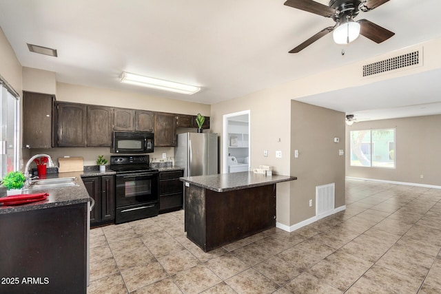 2645 W Elm St, Phoenix, AZ 85017 - kitchen with black appliances, a sink, dark countertops, light tile patterned floors, and a peninsula