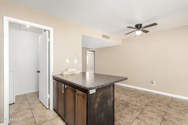 2645 W Elm St, Phoenix, AZ 85017 - kitchen featuring a ceiling fan, light tile patterned flooring, dark brown cabinets, a peninsula, and dark countertops