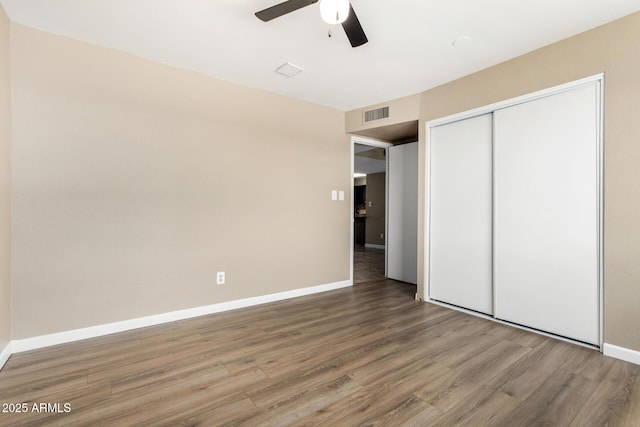 2645 W Elm St, Phoenix, AZ 85017 - unfurnished bedroom with wood finished floors, a closet, baseboards, and a ceiling fan
