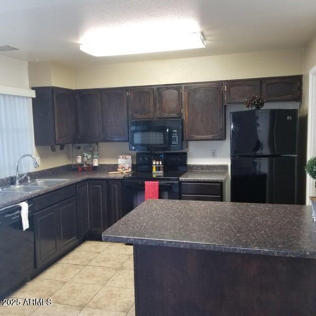 2645 W Elm St, Phoenix, AZ 85017 - kitchen featuring black appliances, a sink, light tile patterned floors, and dark brown cabinetry