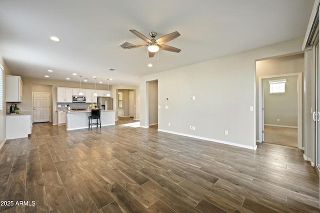 unfurnished living room with ceiling fan and dark hardwood / wood-style flooring