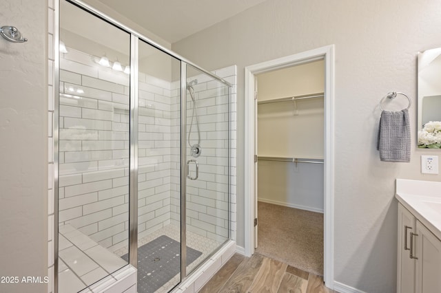 bathroom with vanity, wood-type flooring, and walk in shower