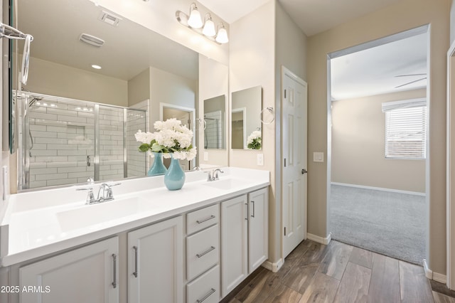 bathroom featuring vanity, wood-type flooring, and a shower with shower door