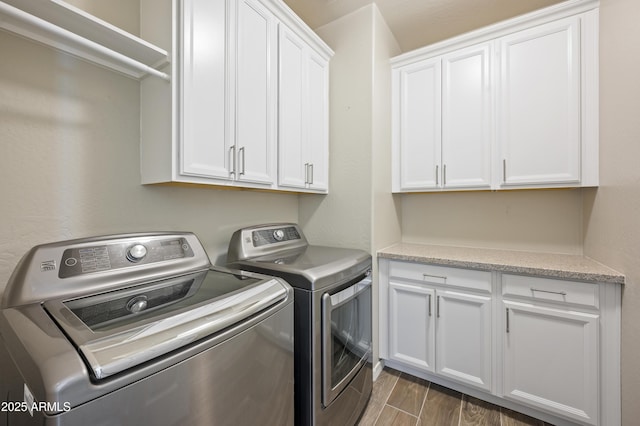 clothes washing area featuring cabinets and washing machine and dryer