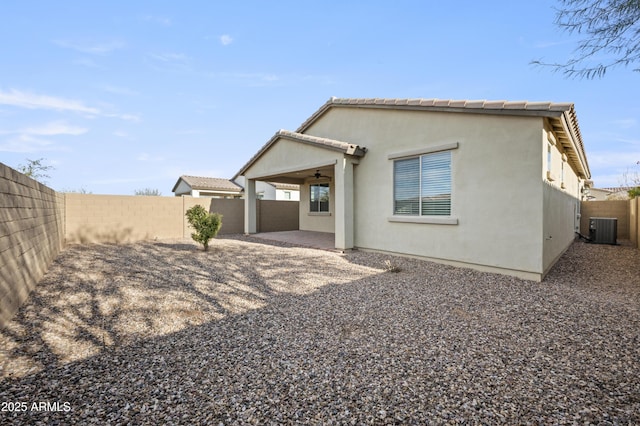 back of property with cooling unit, ceiling fan, and a patio