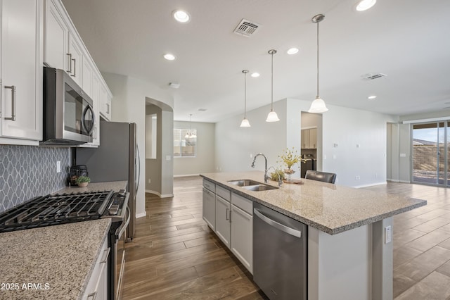 kitchen featuring a kitchen island with sink, sink, stainless steel appliances, and white cabinets