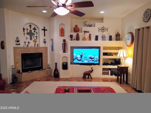 living room with a tiled fireplace, a ceiling fan, and recessed lighting