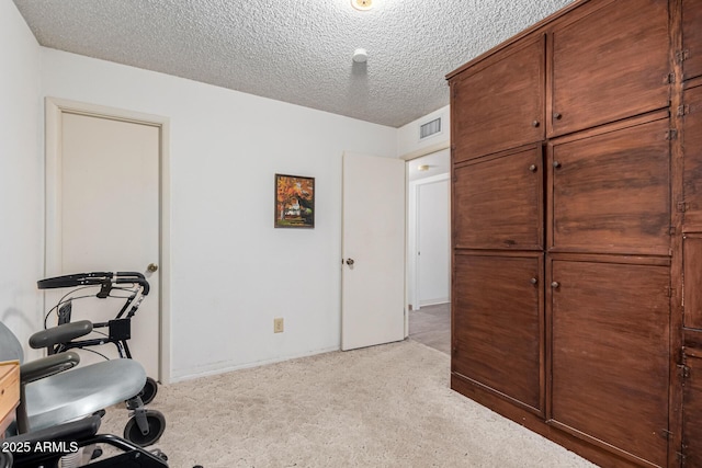 carpeted office space featuring a textured ceiling