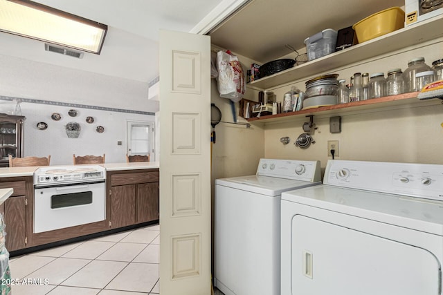 laundry room with light tile patterned flooring and washing machine and clothes dryer