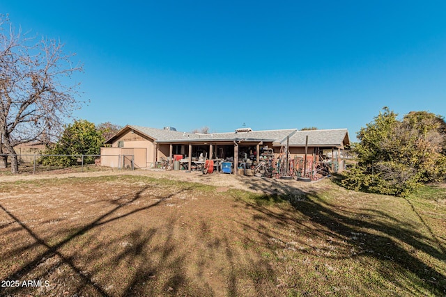 rear view of house featuring a patio and a yard