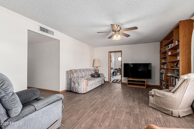 living room featuring ceiling fan, hardwood / wood-style floors, and a textured ceiling