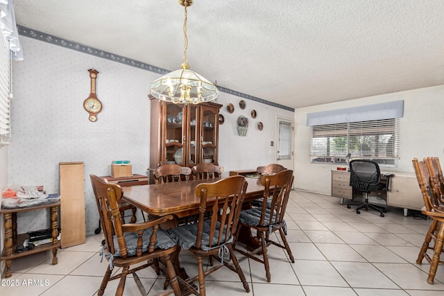 tiled dining space with a textured ceiling