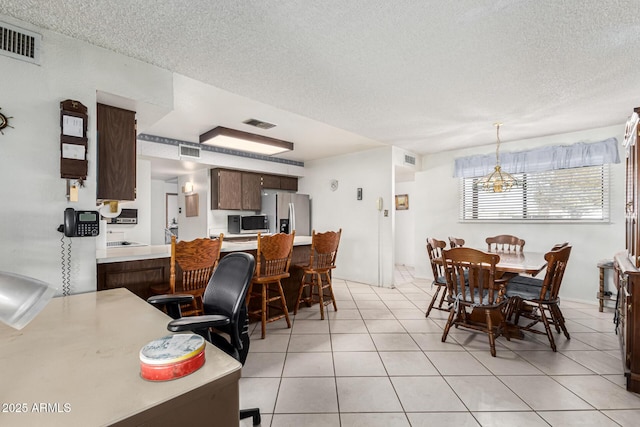 tiled dining area with a textured ceiling