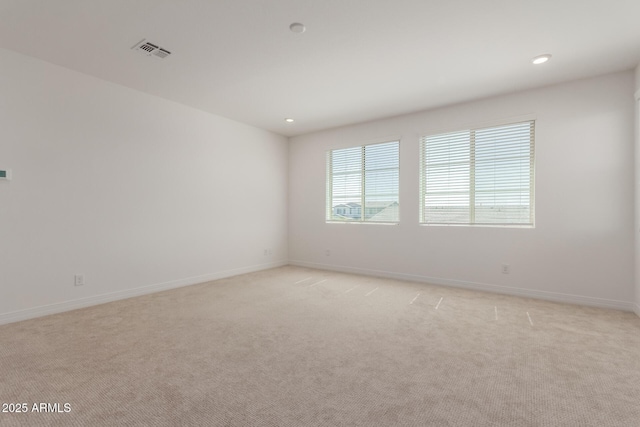 spare room featuring recessed lighting, visible vents, light colored carpet, and baseboards